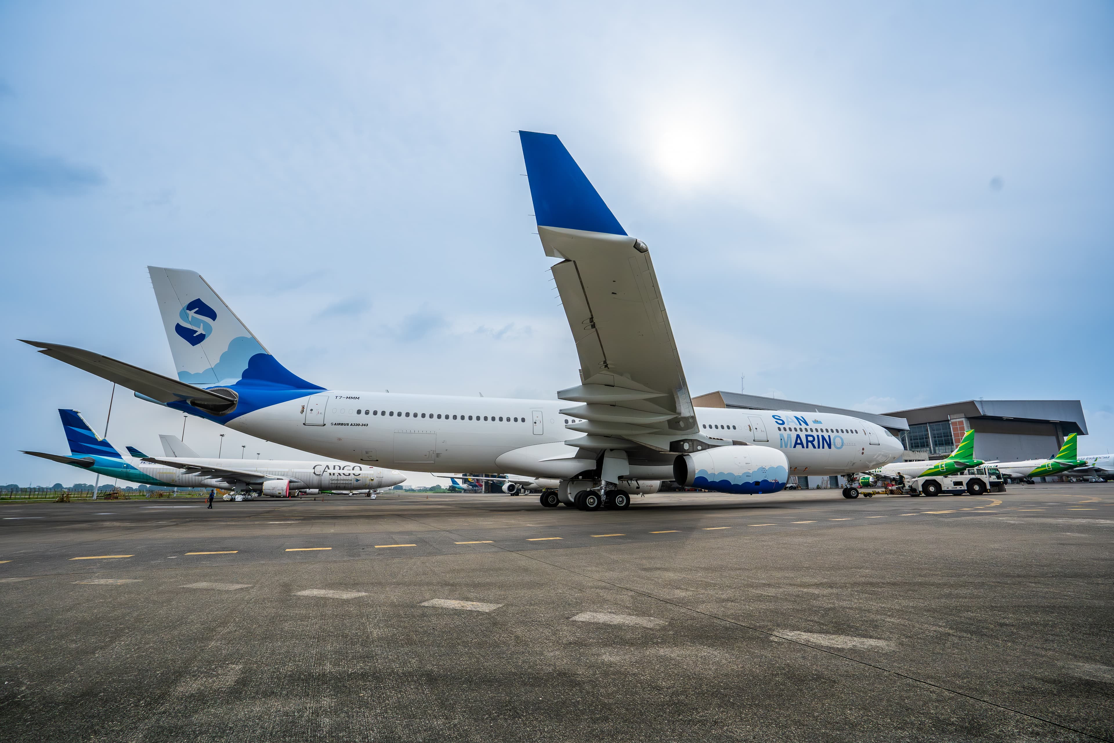 Low angle view of Airbus A330-300 T7-MMM on the apron, its blue winglet raised against the sky
